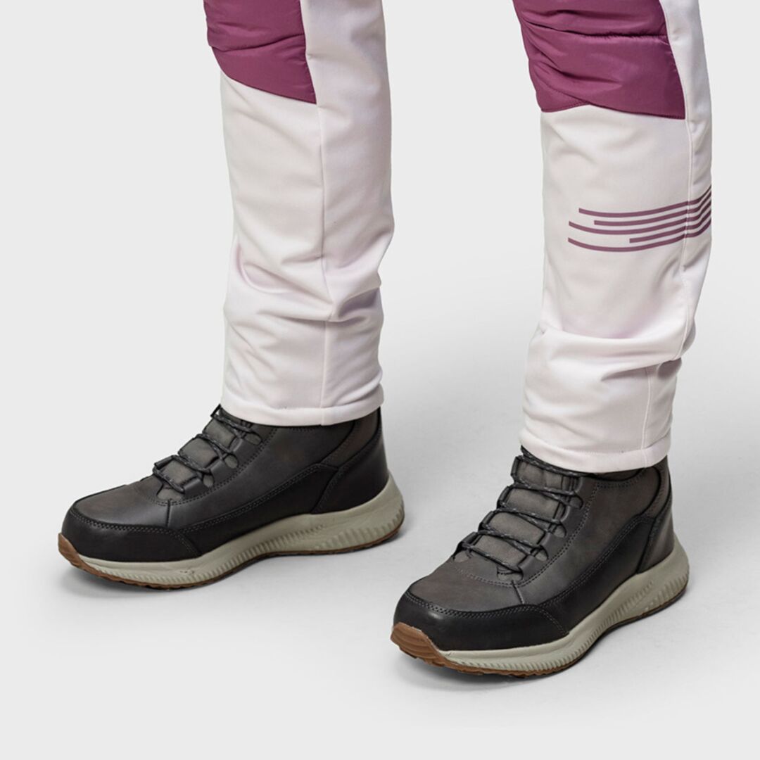 Person iklädd Halti Dundee Mid DX Vinterskor Dam med tjocka sulor och ljusrosa byxor, stående på en grå yta.