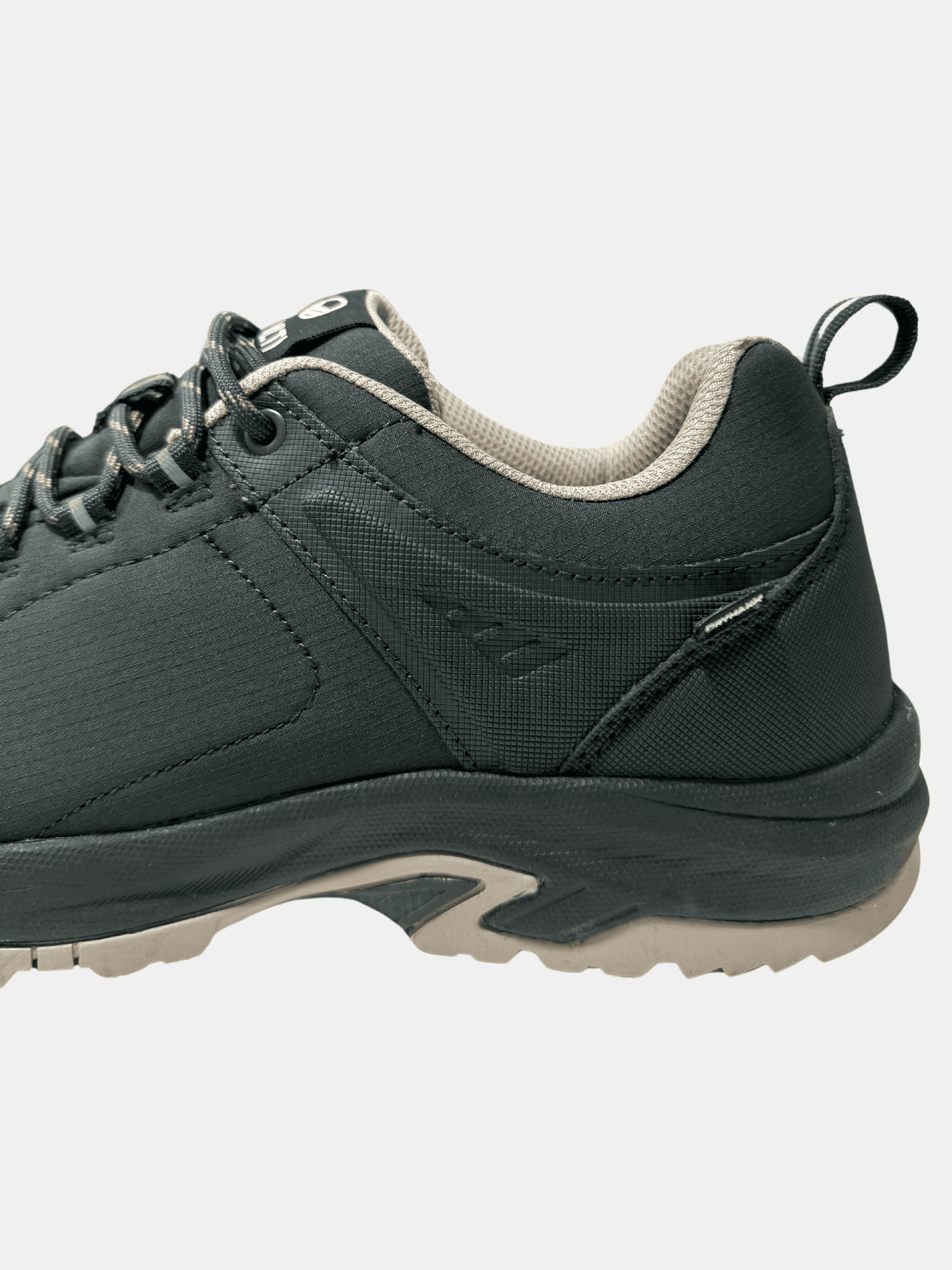 Närbild på Halti Outdoorskor DX Low Herr, svart med beige foder och GripmaxX Antislip-yttersula, mot en ljus bakgrund.