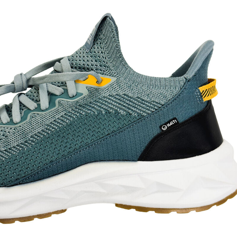 Närbild från sidan av Halti Sottung Sneaker Herr i blågrön med Boomax-mellansula, vit sula och gula och svarta detaljer.