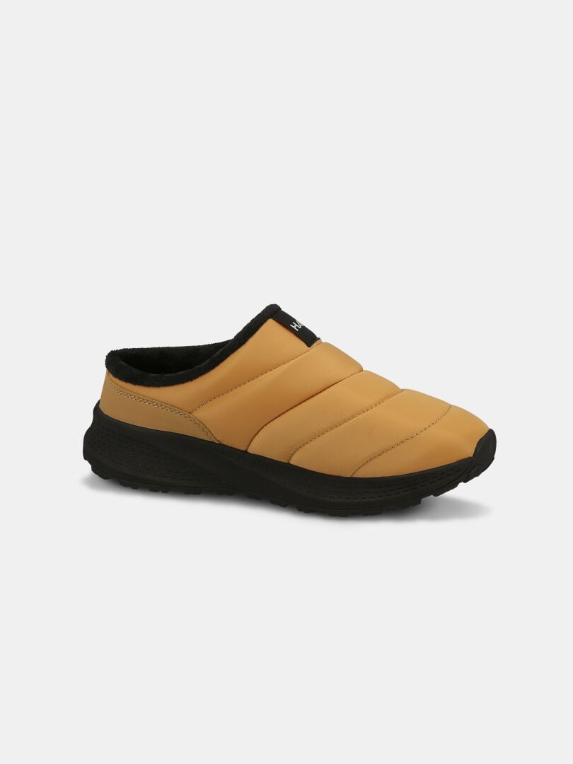 Halti Rest 2 Tofflor: beige slip-on-sko med innersula av minnesskum, vadderat ovandel, svart EVA-sula och kantband, på vit bakgrund.