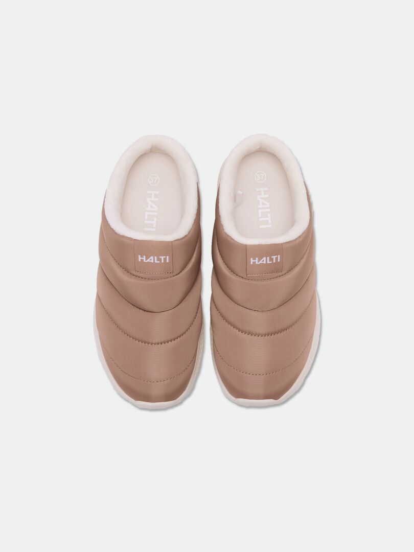 Halti Rest 2 Tofflor: bruna slip-on-skor med innersulor av minnesskum, vit insida, sett uppifrån mot en ljus bakgrund.