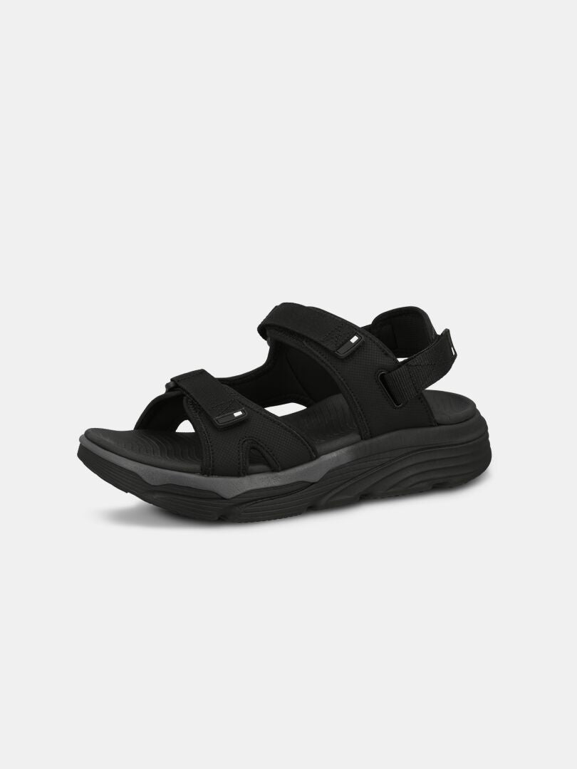 Halti Pursuit 2 Sport Sandal är svart, öppen tå, med justerbart kardborreband och en sneakerliknande sula på vit botten.