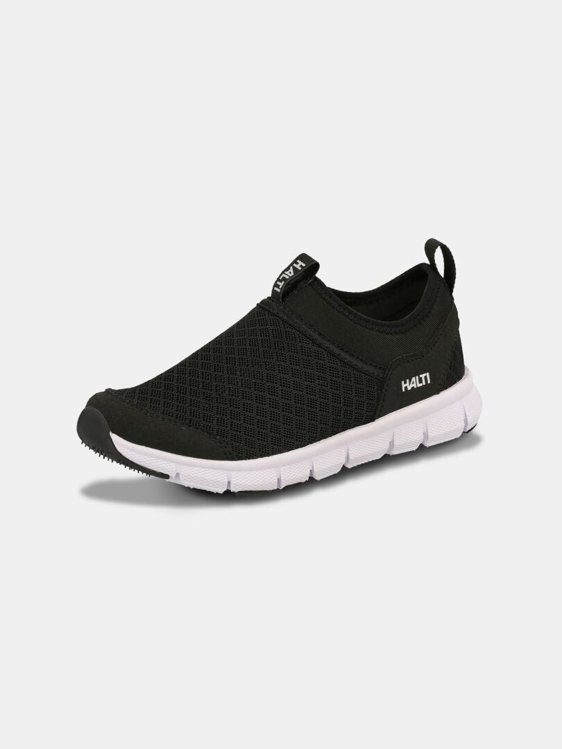 Lente 3 Fritidsskor Junior från Halti är en svart slip-on-sko med mesh och en vit phylonsula, samt logotyp på sidan.