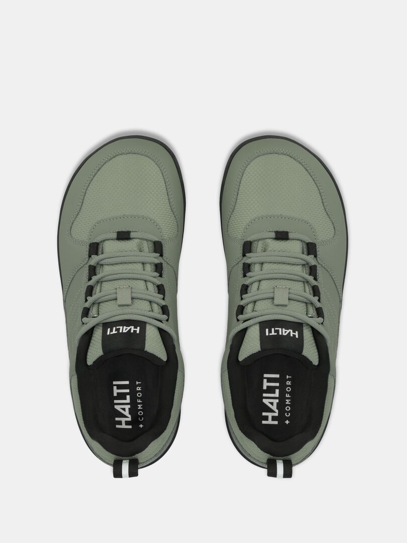 Ett par Halti Tuntuma DX Barfotaskor Dam, ljusgröna sneakers med svarta detaljer, sett uppifrån på vit bakgrund.