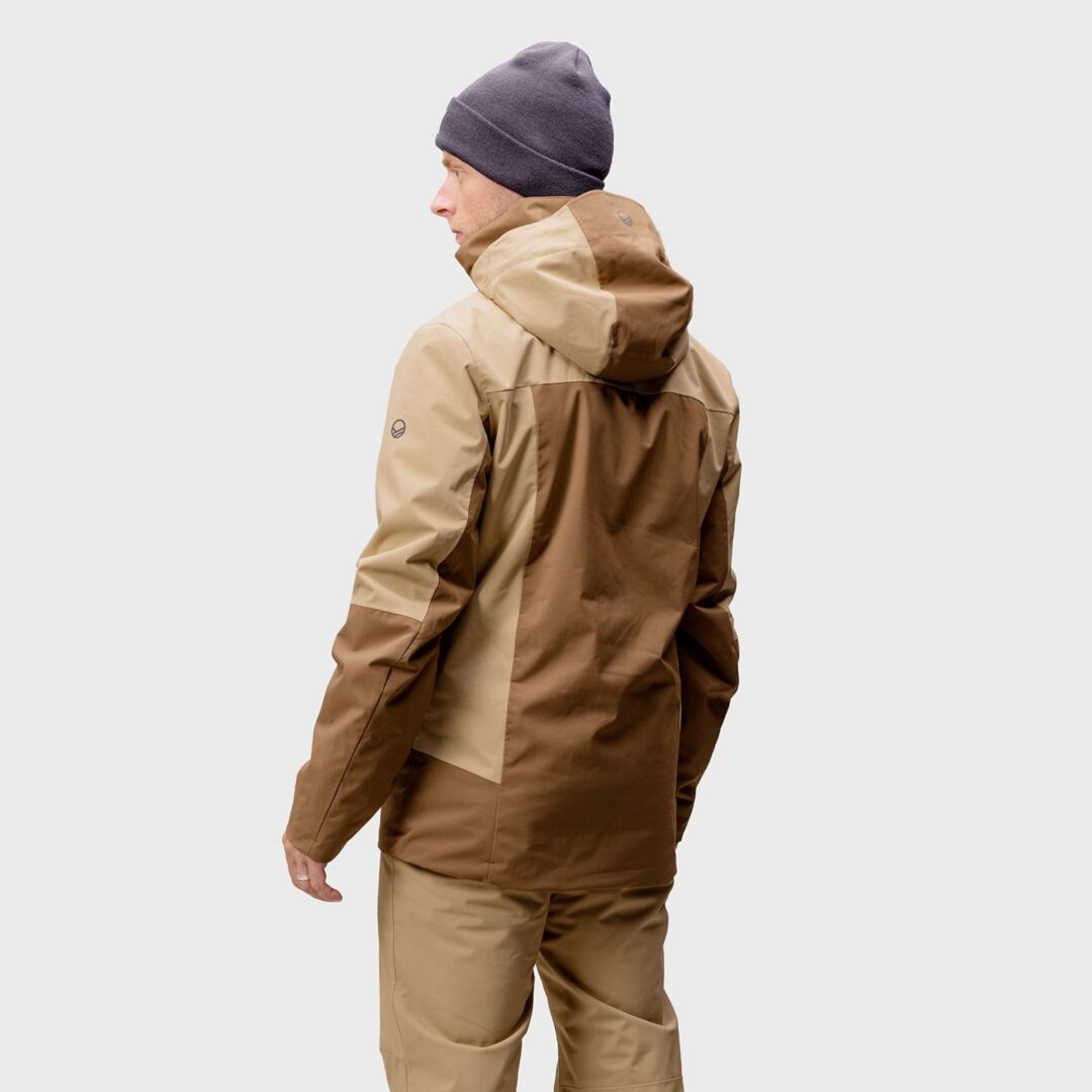 En person i Halti Planker DX Skidjacka Herr, matchande byxor och grå mössa, vänd bort från kameran.