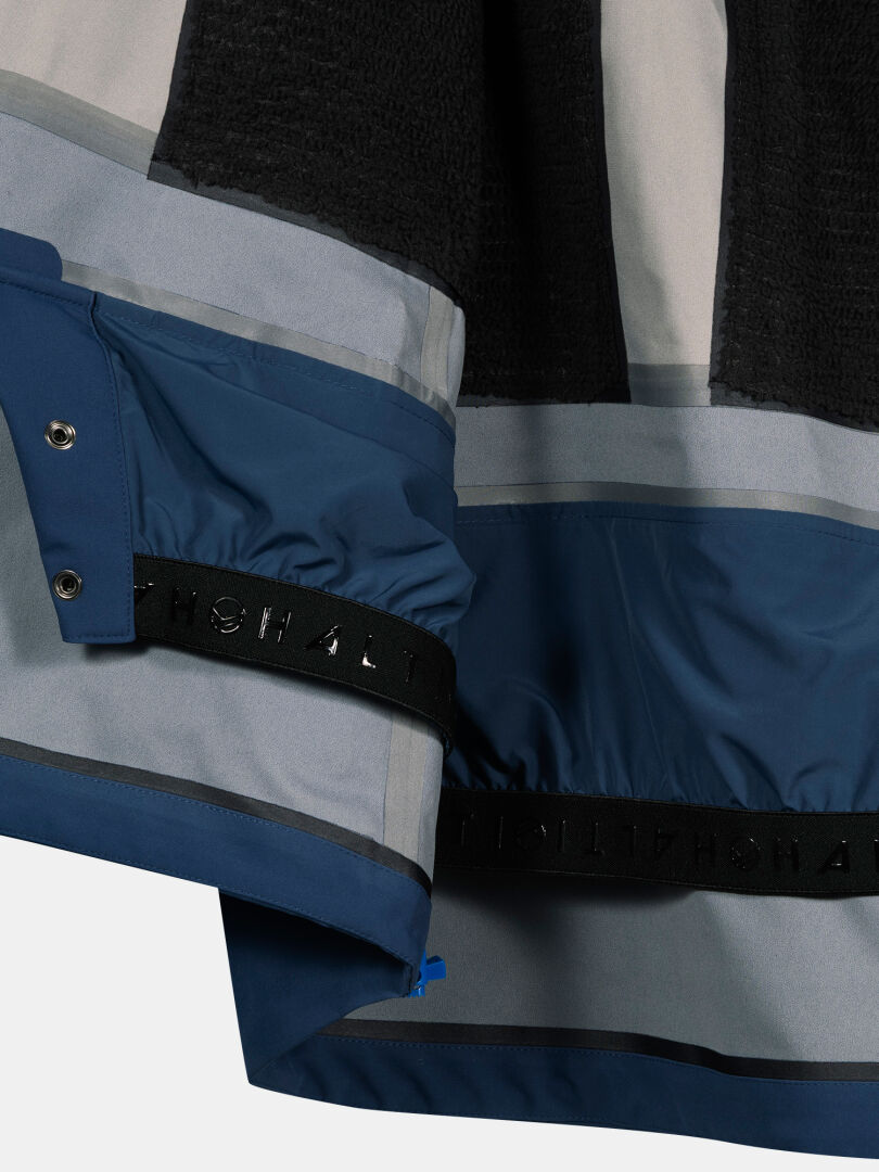 Närbild av Halti Rizle 3L DX Skidjacka Unisex som visar innerfoder, tryckknappar och ett svart elastiskt band med text.