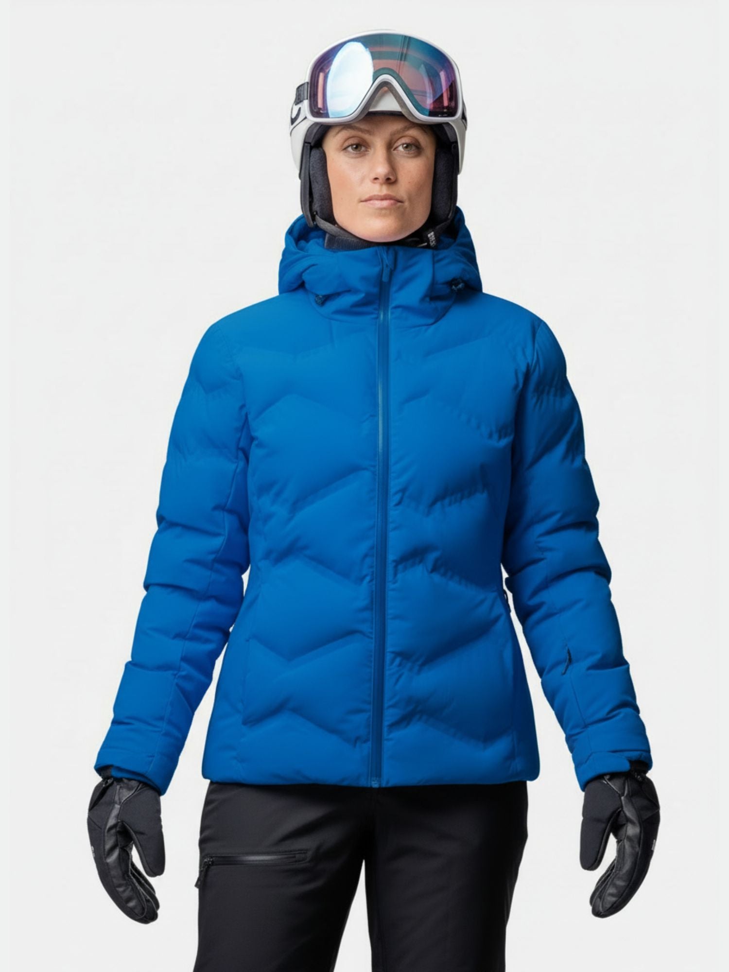 Person i Halti Nordic Arcty II Skidjacka Dam, svarta skidvantar, byxor, hjälm och skyddsglasögon står vänd framåt.