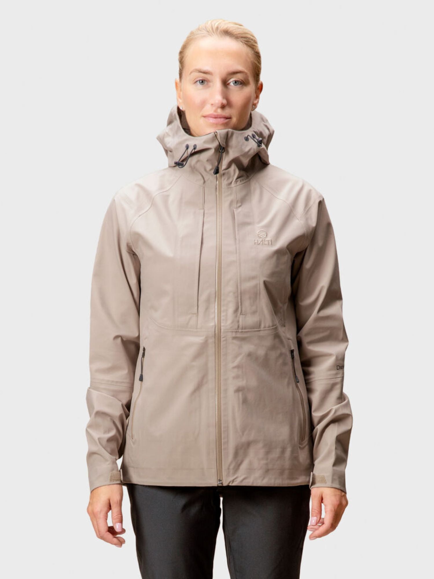 En person bär Halti Kaarna Dam DrymaxX 3L Skaljacka, perfekt för friluftsliv, mot en enfärgad bakgrund.