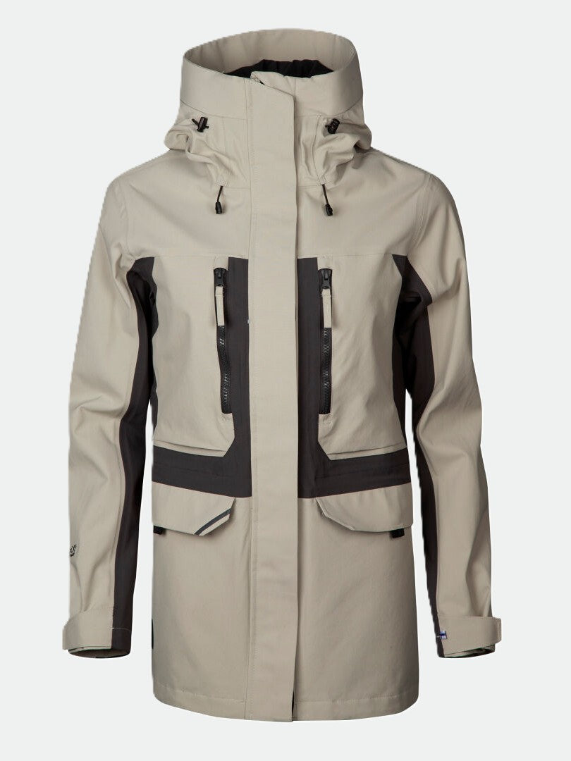 Halti Hiker Dam DrymaxX Parka Jacka i beige/svart med dragkedjeförsedda fickor, på en enfärgad ljus bakgrund.