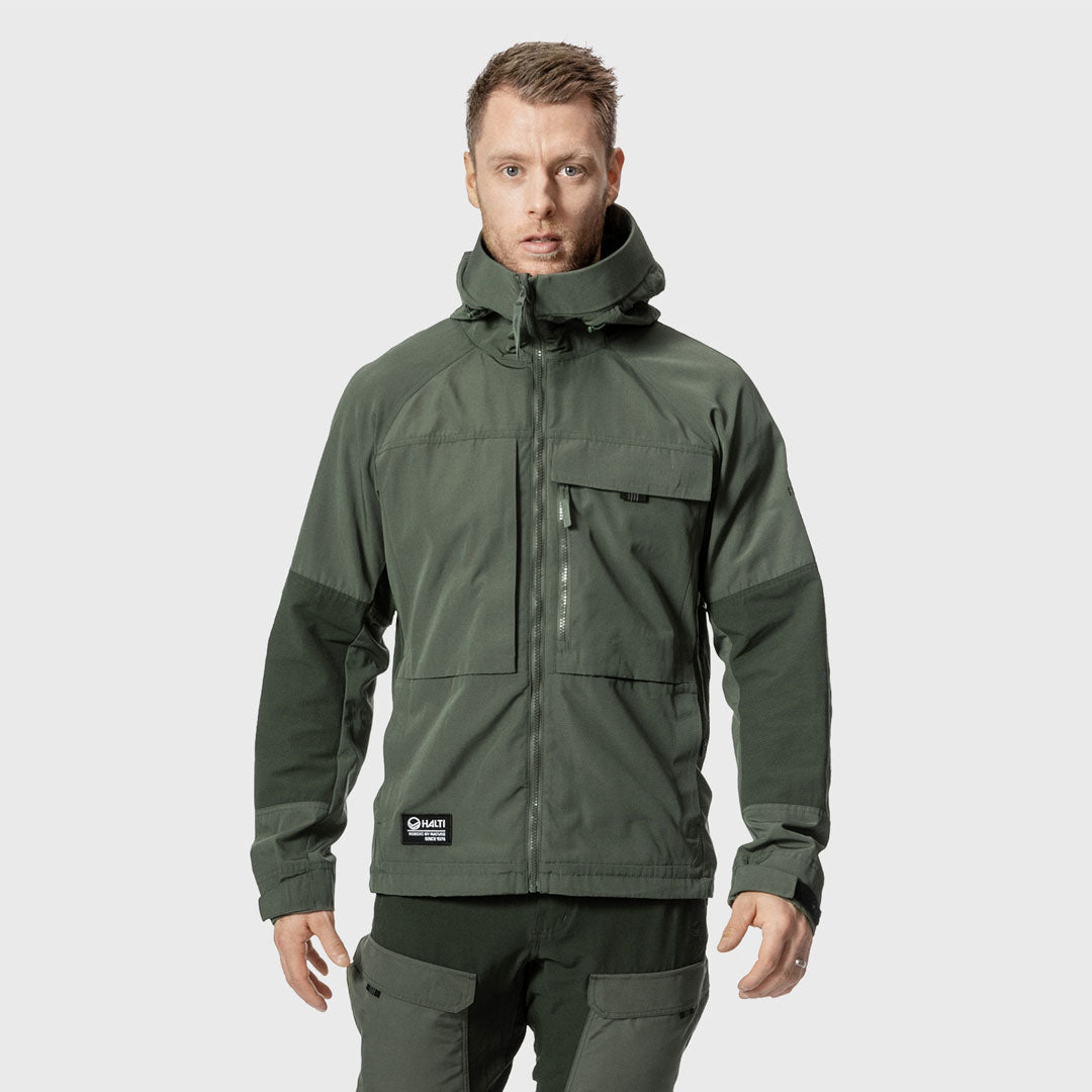 En man bär Halti Hiker Herr Ventilated Jacka med matchande byxor, stående mot en enfärgad ljus bakgrund.