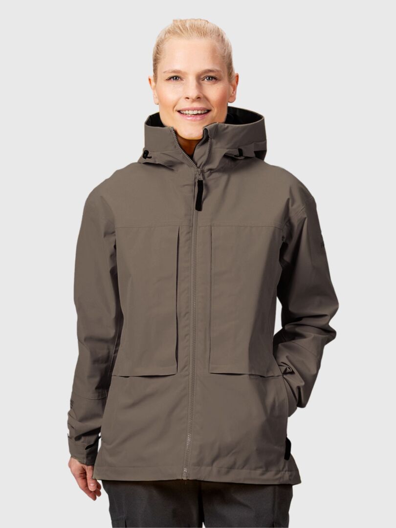 En kvinna i en grå Halti Hiker II DrymaxX Skaljacka står vänd framåt och ler mot en ljus bakgrund.