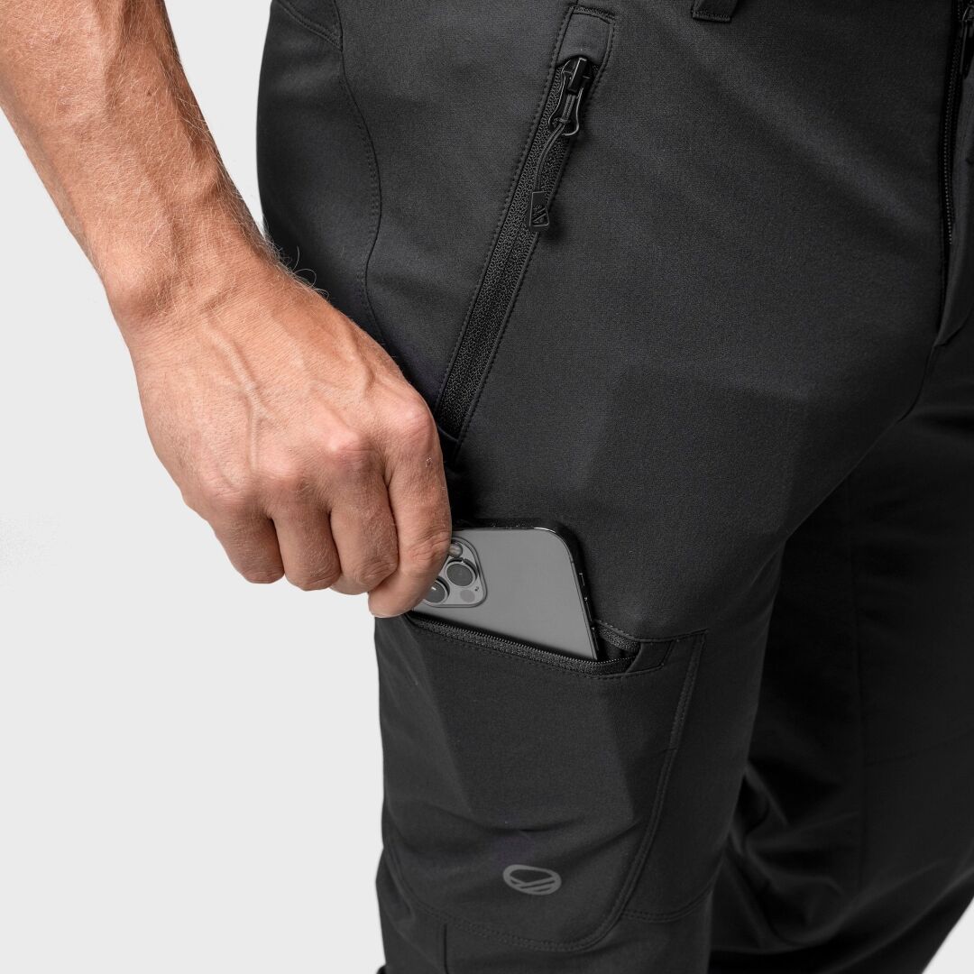 Någon stoppar ner en smartphone i den dragkedjeförsedda lårfickan på Halti Pallas Evo Brushed X-stretch Byxor Herr.