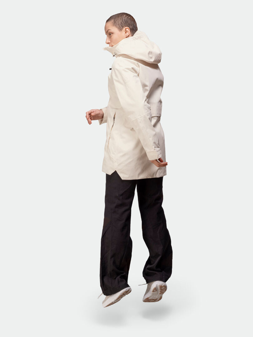 En person i Halti Kallas DX Parka Dam hoppar mot en vit bakgrund.