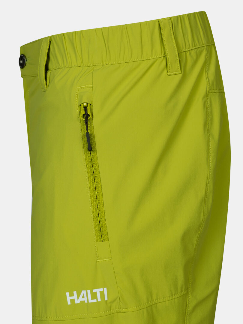 Närbild på Halti Pallas Cool X-stretch Shorts Herr i ljusgul-grön färg med dragkedjeficka och logotyp vid knät.