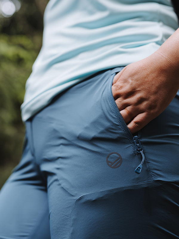 Person som bär Halti Pallas Cool X-stretch Capribyxor Dam Plus med dragkedja och ljusblå skjorta.