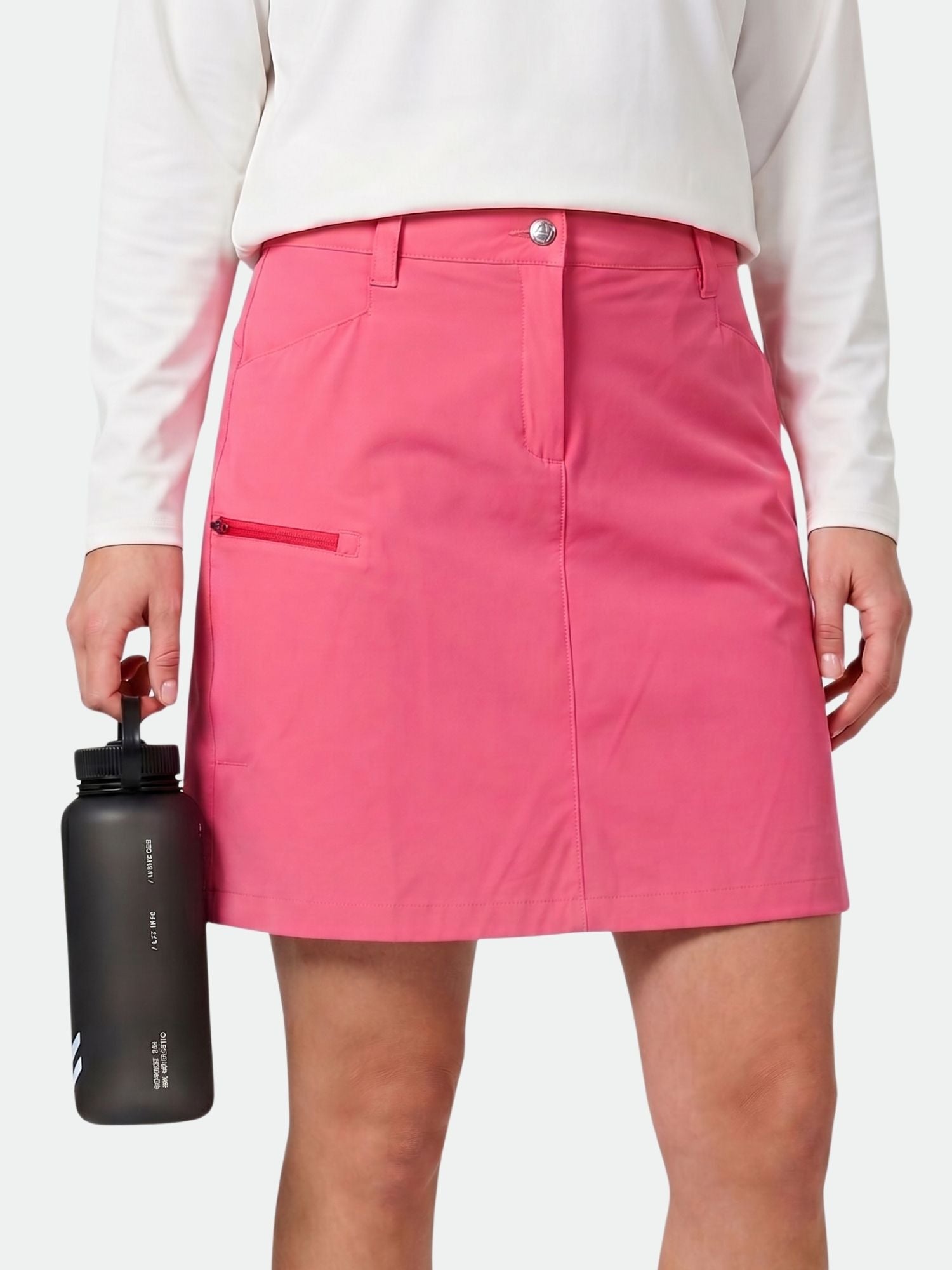 Person i vit långärmad tröja och Halti Pallas Cool Skjol Dam (rosa), håller i en svart vattenflaska.