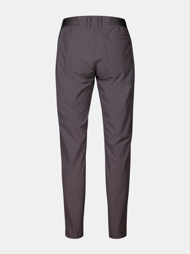 Bakifrån på Halti Drive X-stretch Chinos Dam med bälteshällor och passpoalfickor, mot enfärgad bakgrund.