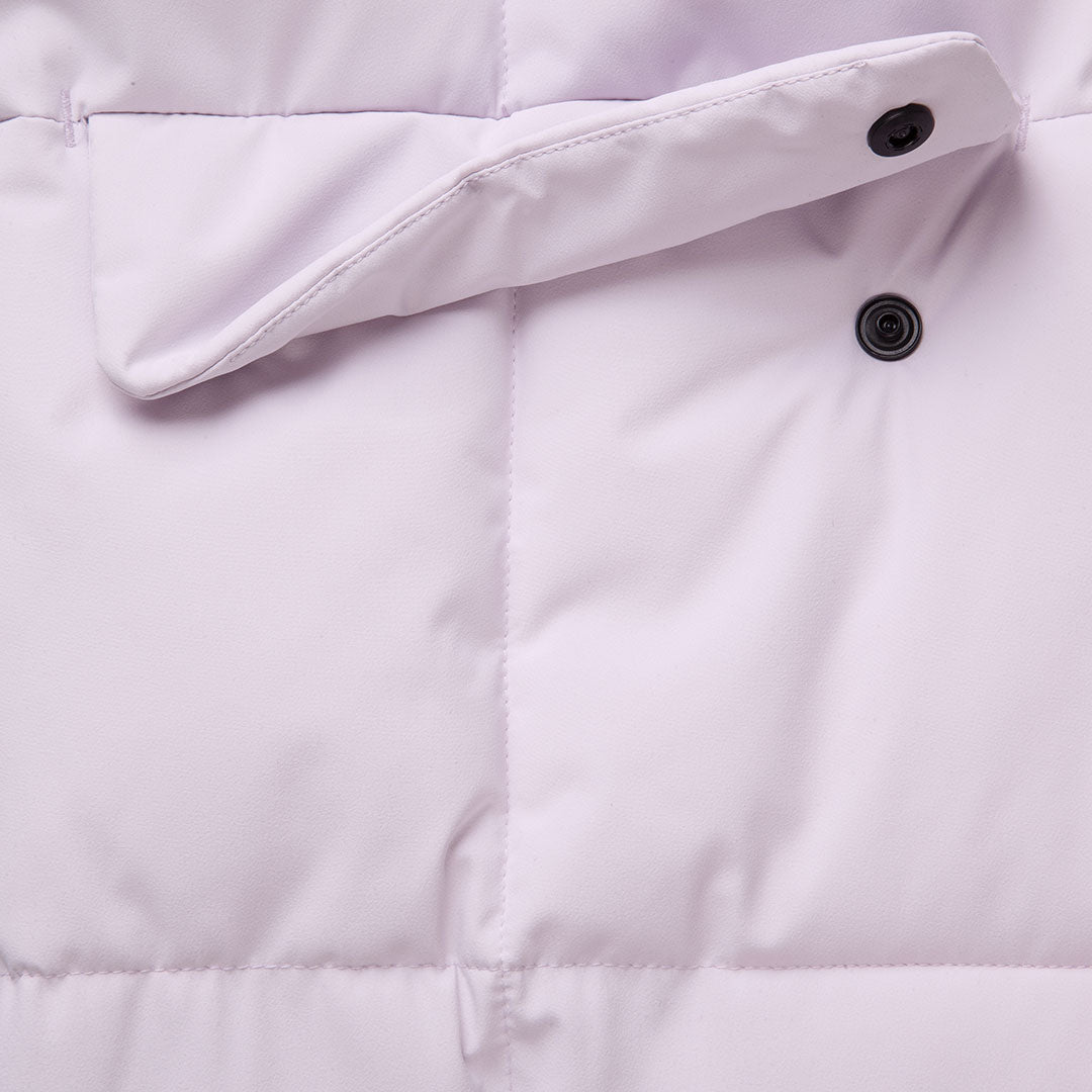 Närbild av Halti Penger Vinterjacka Dam i ljuslila, som visar en flik med svart tryckknapp och sömmar.