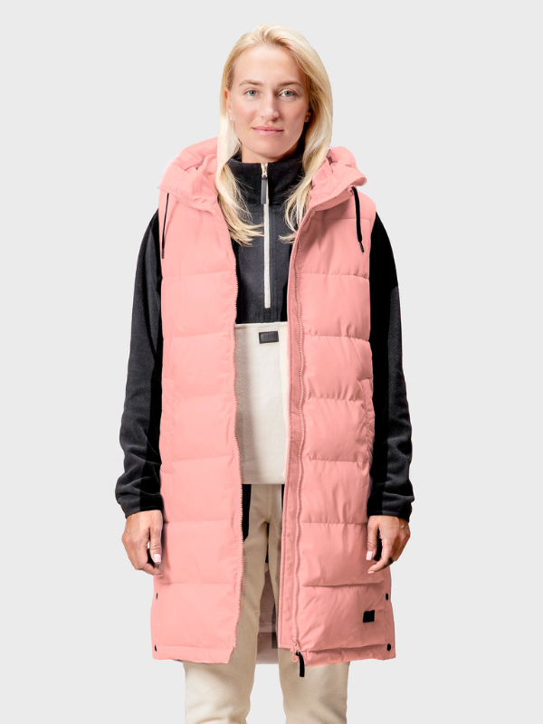 En person bär Halti Penger Puffer Väst Dam över en svartvit outfit och står mot en enfärgad bakgrund.
