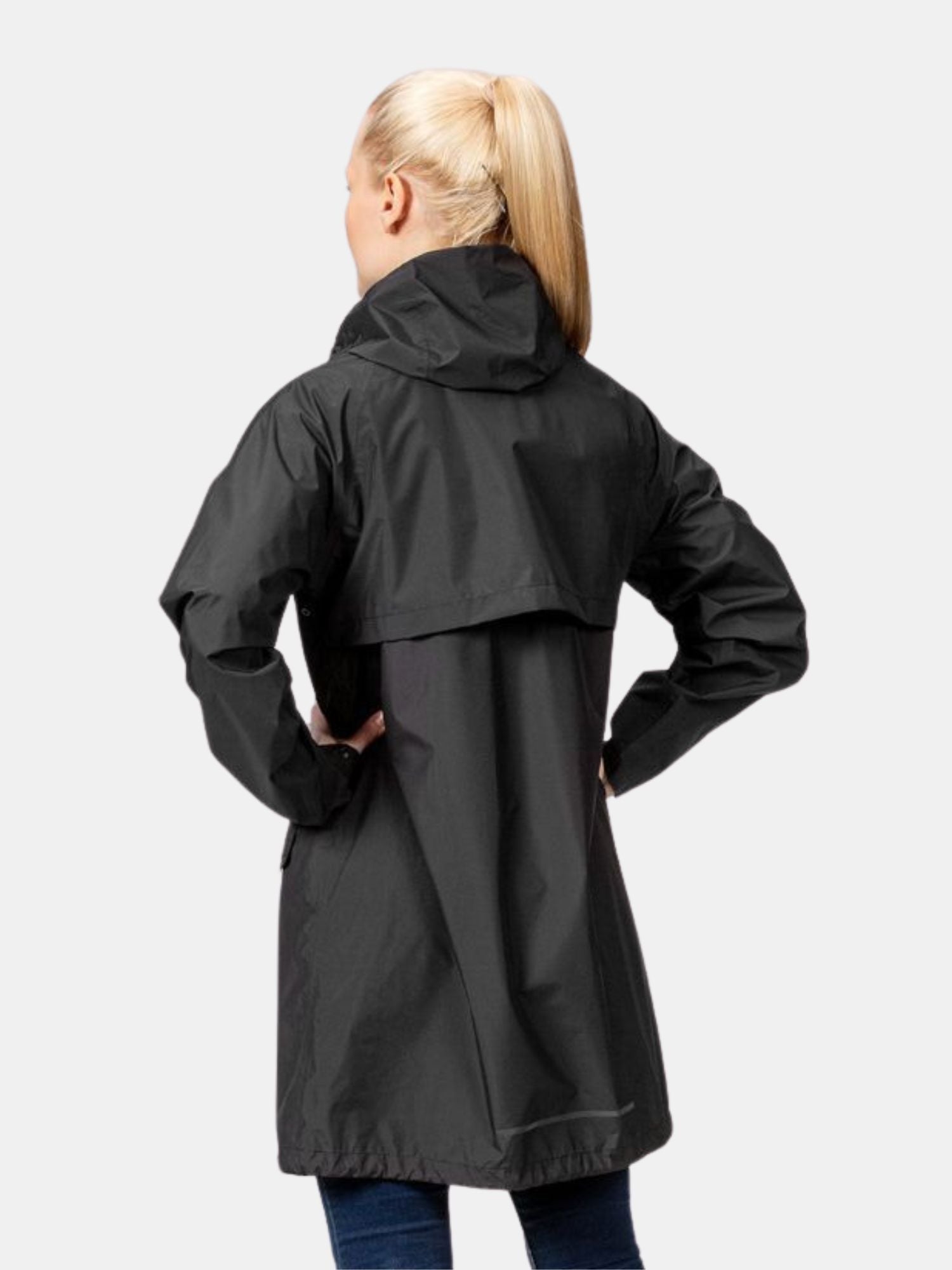 En kvinna i Halti Kevee Parka Jacka Dam står med händerna på höfterna och visar sin väderbeständighet.