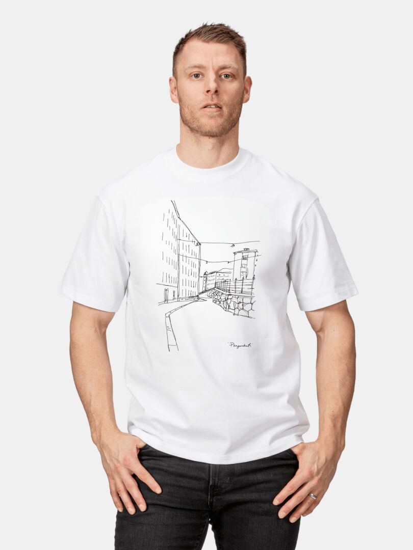 En man bär en Halti Skaltsi unisex t-skjorta med ett svart stadsgatumönster på ekologisk bomull.