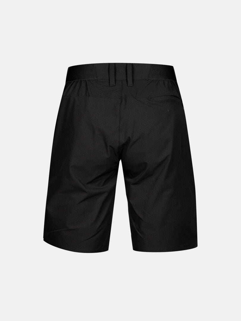Halti Drive X-stretch Shorts Dam i svart, knälånga, visas bakifrån med bälteshällor och passpoalfickor bak.