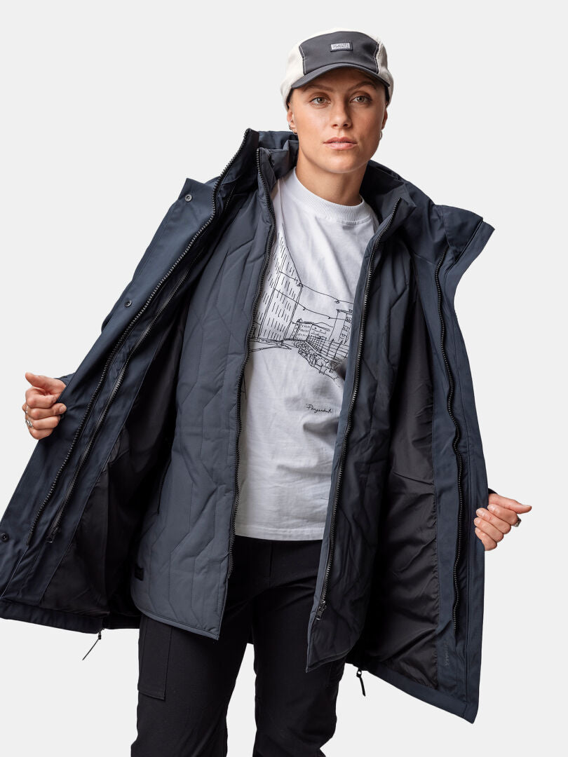 Någon i en ljusgrå keps och grafisk t-shirt avslöjar innerfodret i Halti Synkas 3in1 DrymaxX Parka Dam.