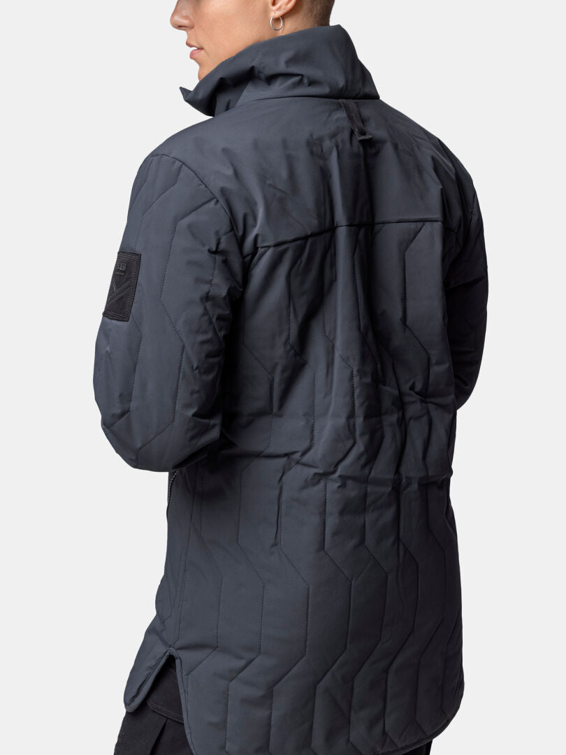Person iklädd Halti Synkas 3in1 DrymaxX Parka Dam med hög krage, fotograferad bakifrån mot en ljus bakgrund.