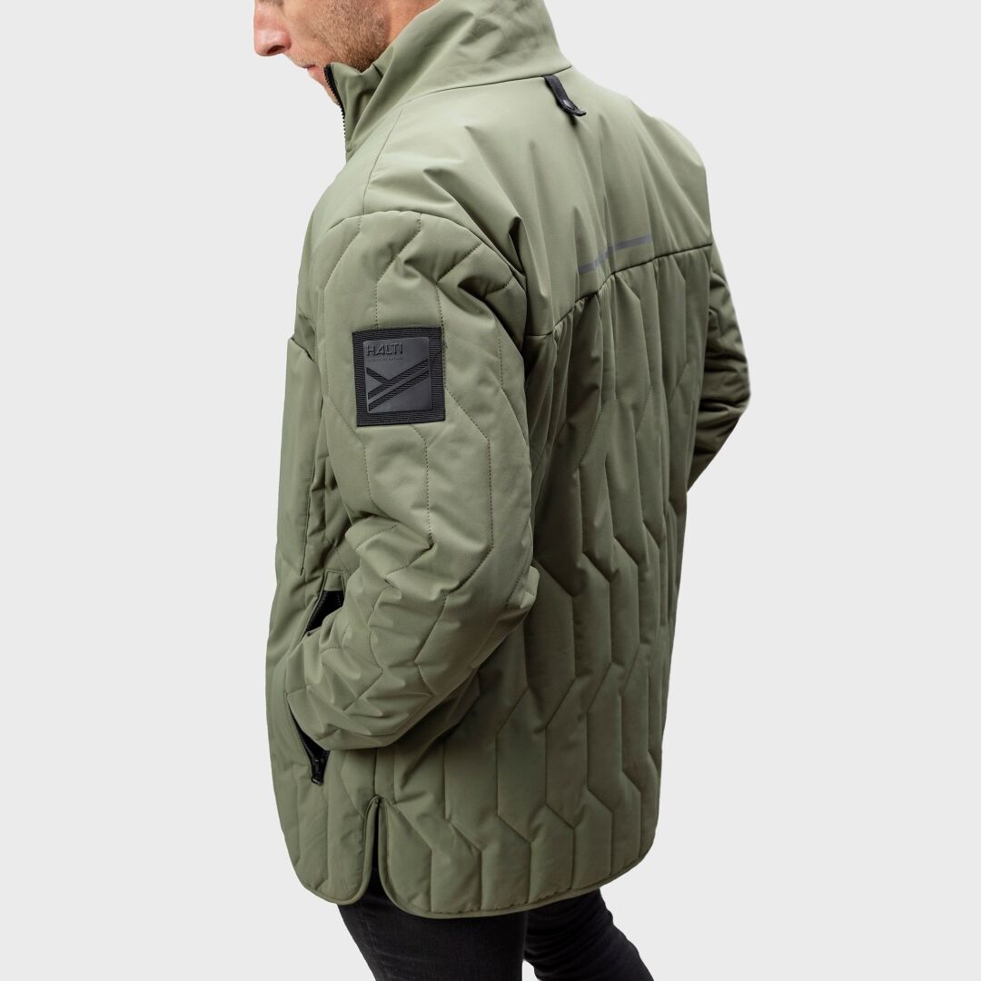 En person i en Halti Synkas 3in1 DrymaxX Parka Herr, sedd från sidan mot en slät bakgrund.