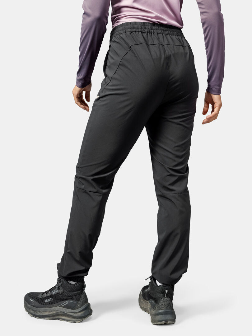 Person iklädd Halti Grets Joggers Dam och en lila långärmad skjorta, perfekt för friluftsliv, sedd bakifrån.