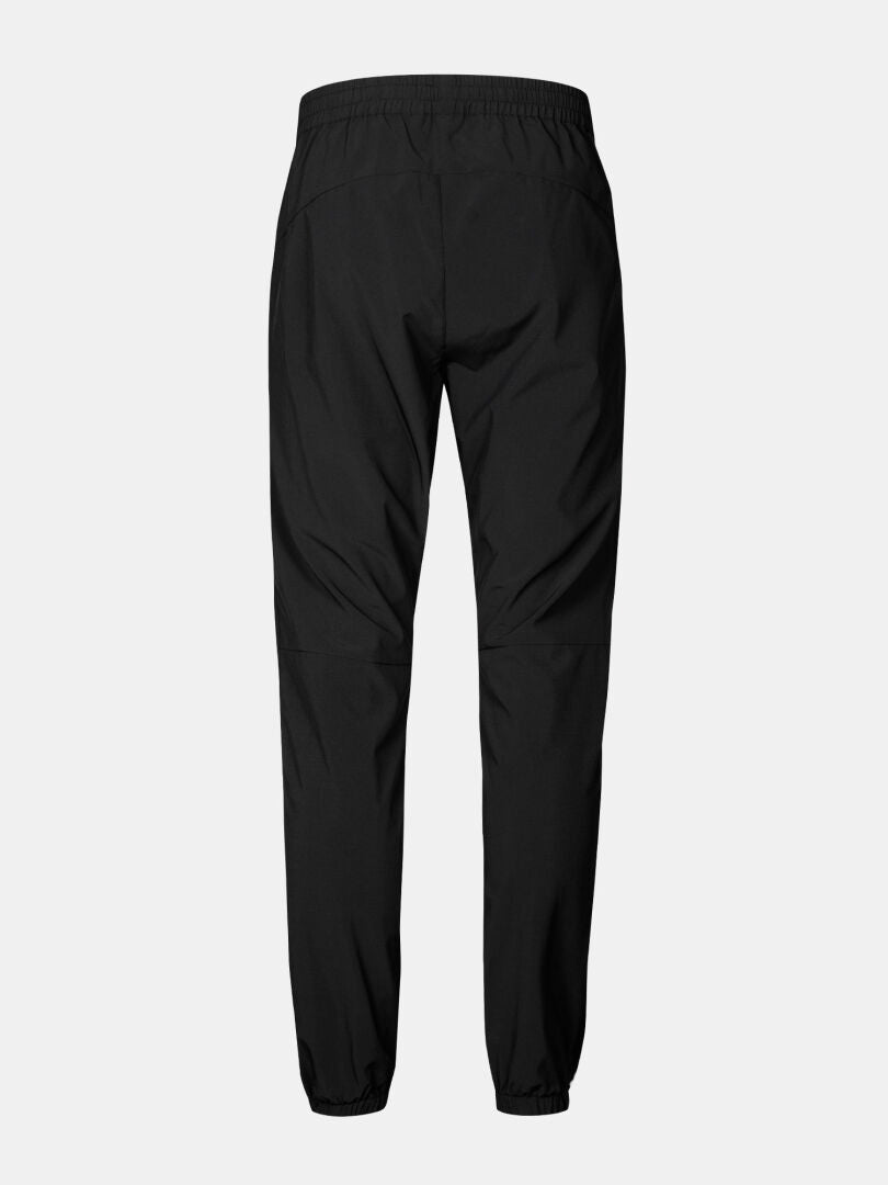 Halti Grets Joggers Herr: svarta joggers med resår i midjan/avslut, Quick Dry Lite Stretch, visas bakifrån på grått.
