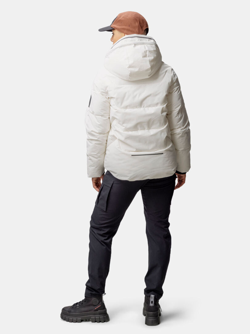 Person klädd i Halti Brahe Puffer Vinterjacka Dam, svarta byxor och stövlar, vänd bort från kameran.