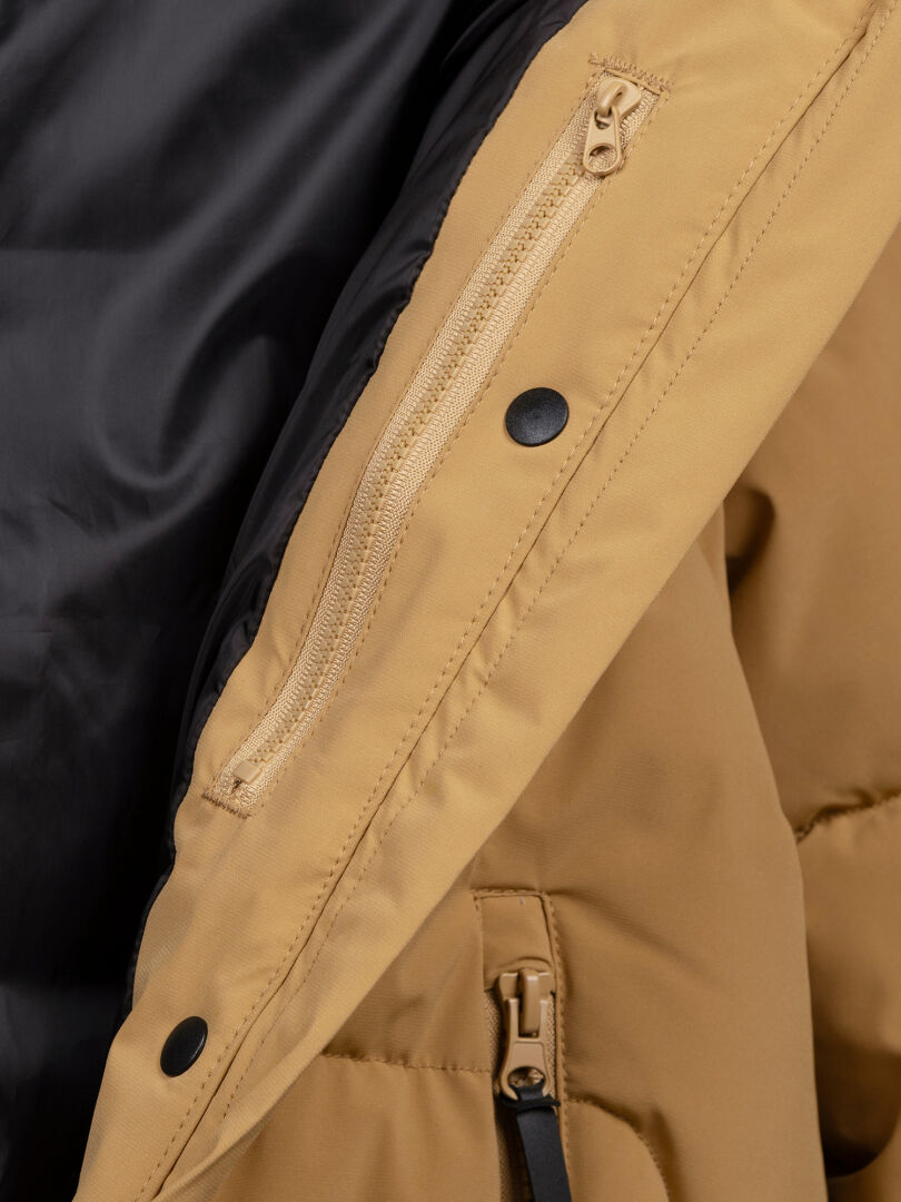 Närbild av Halti Brahe Puffer Vinterjacka Dam i beige, tillverkad av återvunnen polyester med svart foder och innerficka.