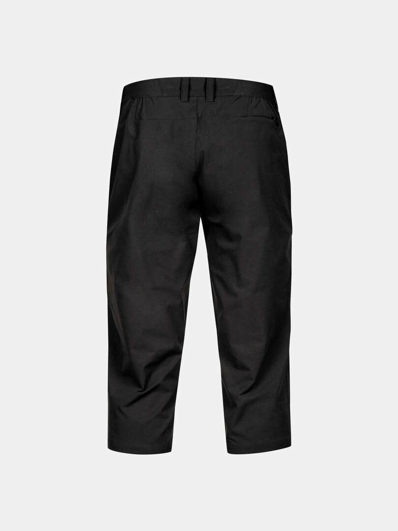 Bakifrån av Halti Drive X-stretch Capribyxor Dam Plus i svart, visad mot en enfärgad ljusgrå bakgrund.