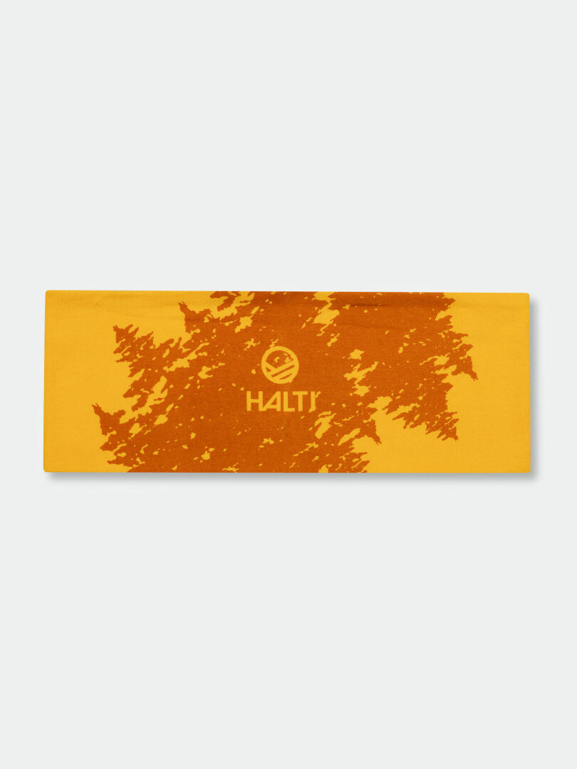 Halti Laava Pannband är gult med ett orange abstrakt mönster, stretchigt material och en vit logotyp i mitten.