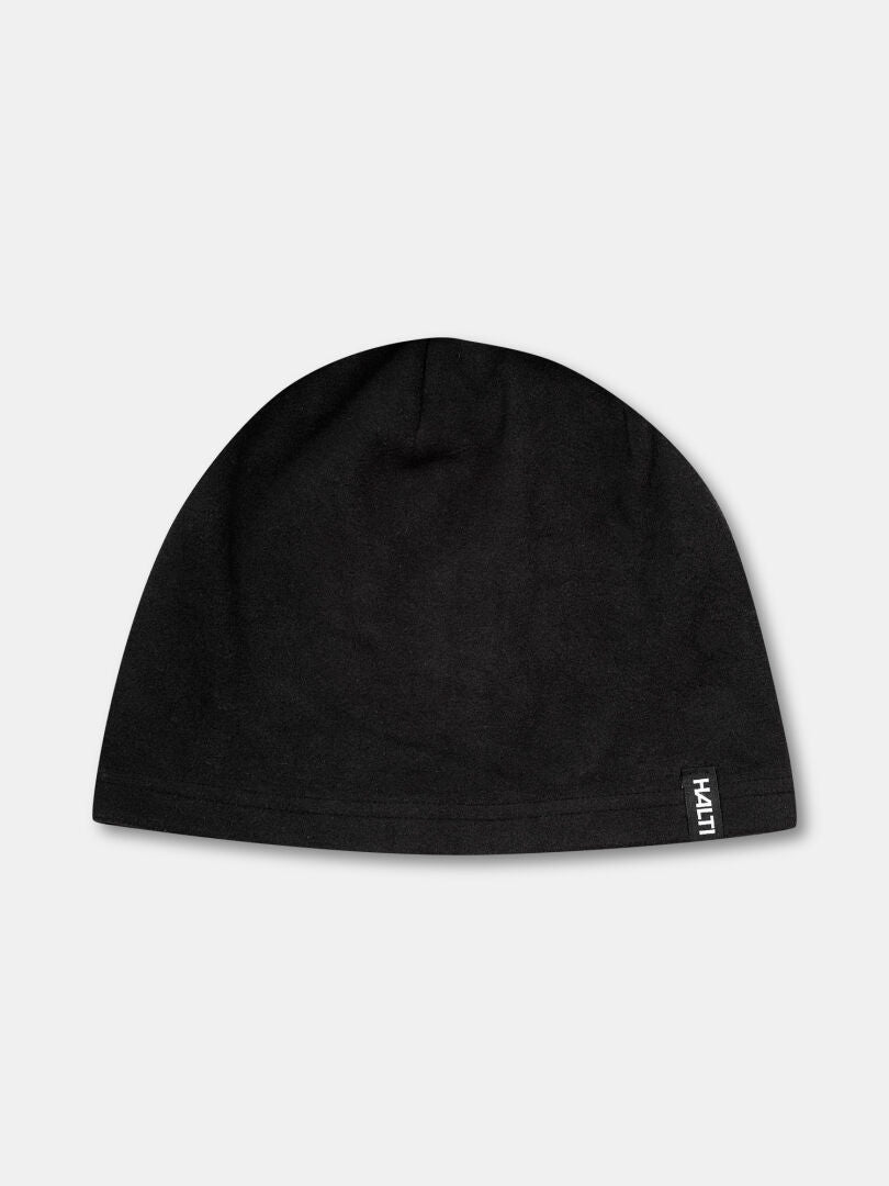 Halti Trone Fleece Mössa är en svart mössa med vit logotyp, perfekt för löpning och vinterträning. Fotograferad i grått.