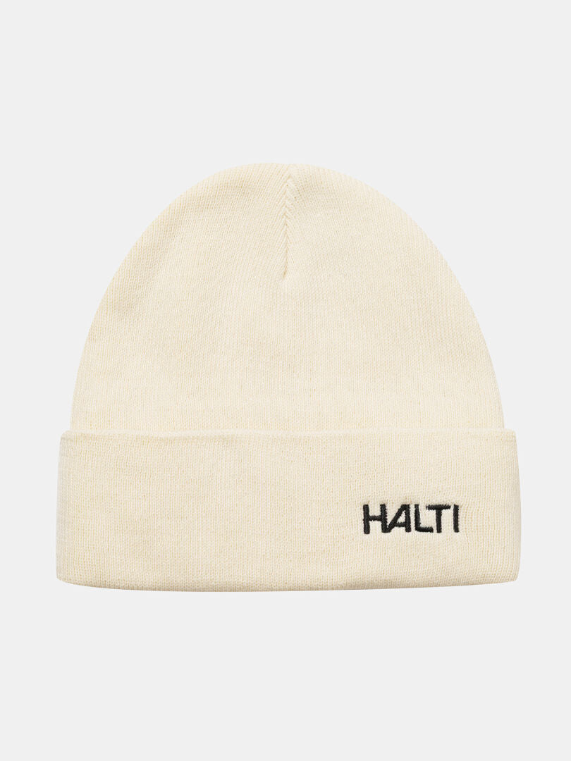 En krämfärgad Justie Mössa från Halti med vikbar skärm, fleecefoder och svart broderi på framsidan.