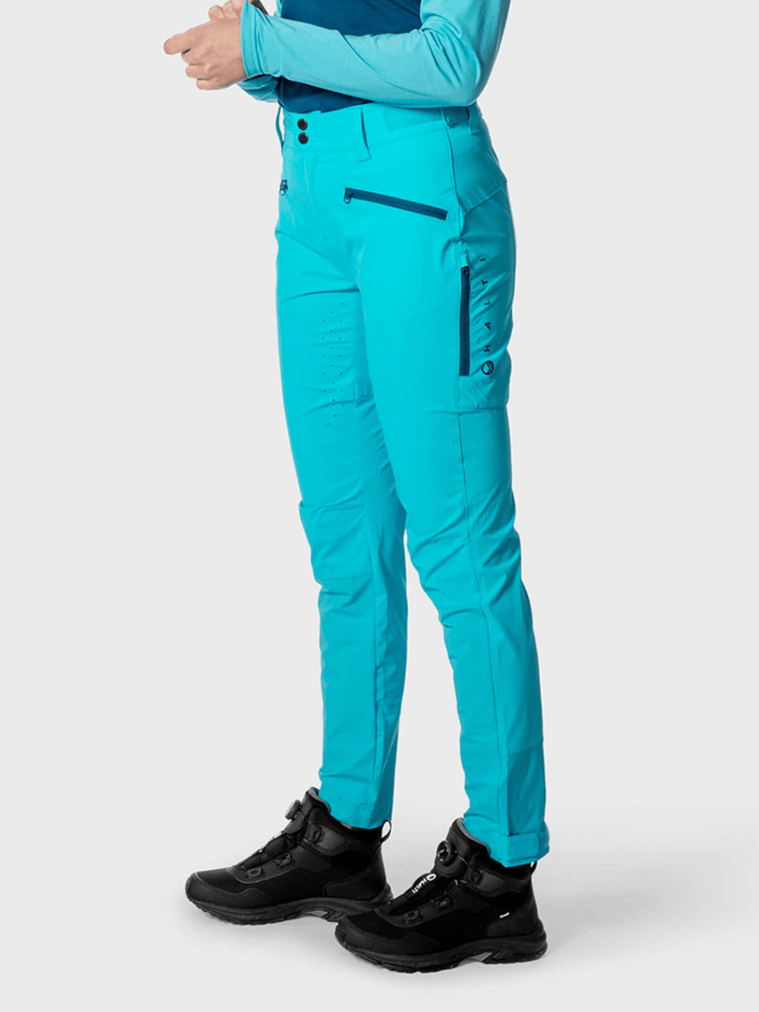 Person som bär Halti Tracks Dam X-stretch Byxor och svarta vandringskängor – perfekt för aktiv utomhusträning.