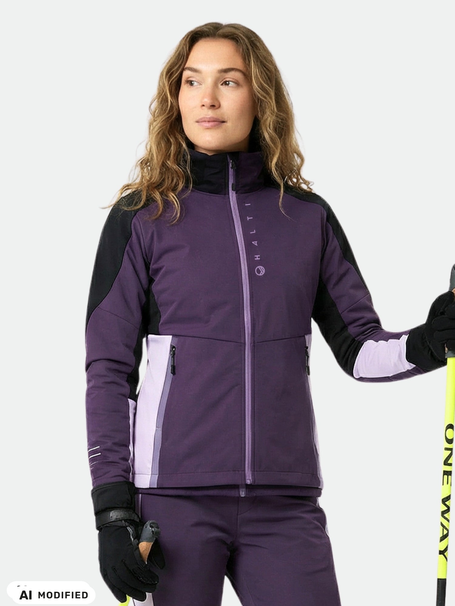 Kvinna i Halti Veloce längdskidjacka och byxor för damer, tillverkade av återvunnen polyester, med skidstavar i händerna.