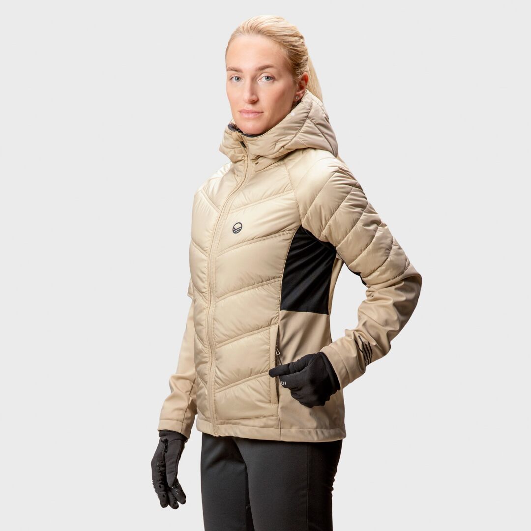 En person bär en beige Halti Hanki Längdskidjacka Dam med svarta paneler och handskar, med återvunnen Microtherm®-stoppning.