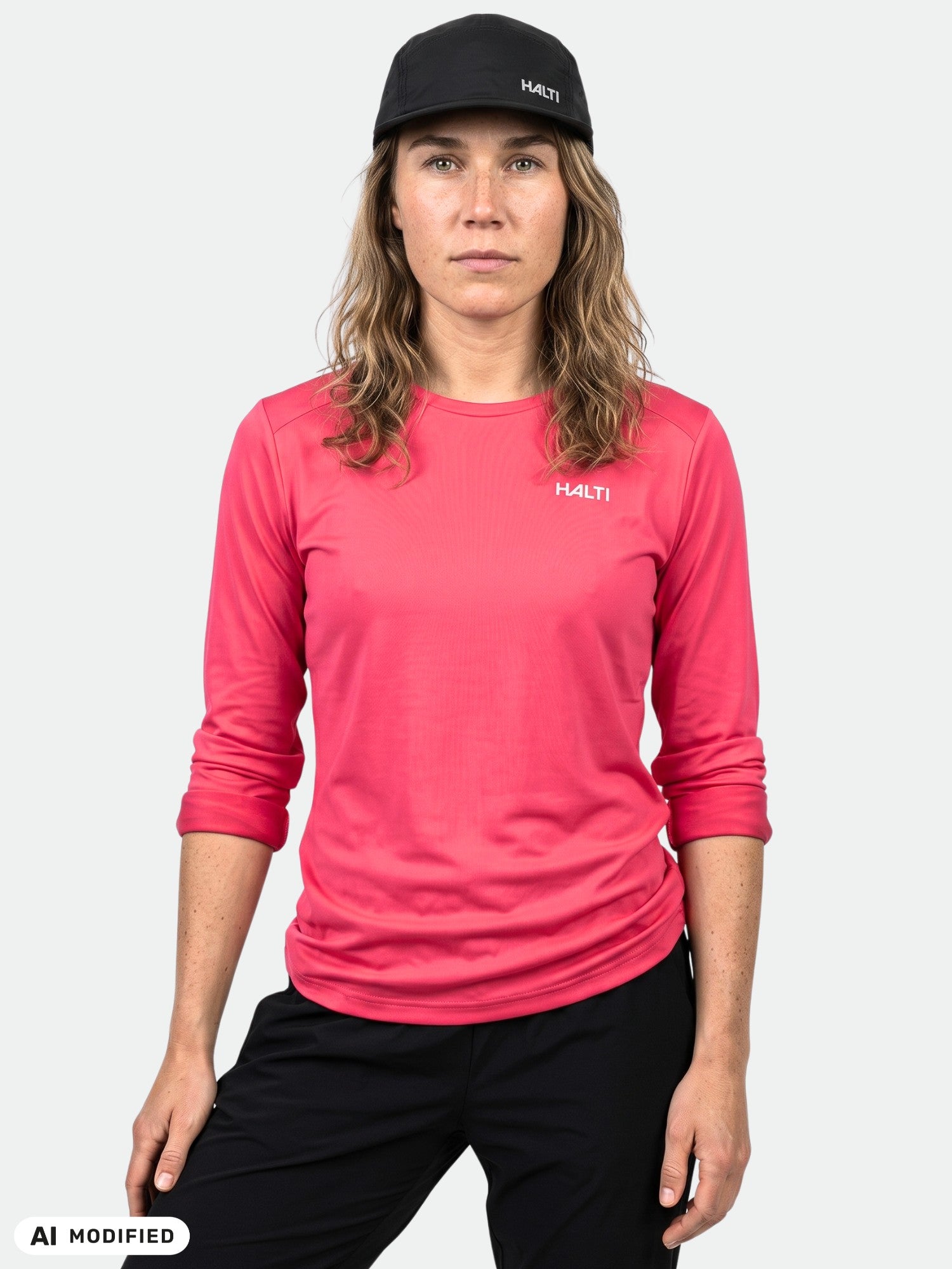 Person klädd i en rosa Halti Salves Träningströja Dam, svarta byxor och en svart Halti-keps.