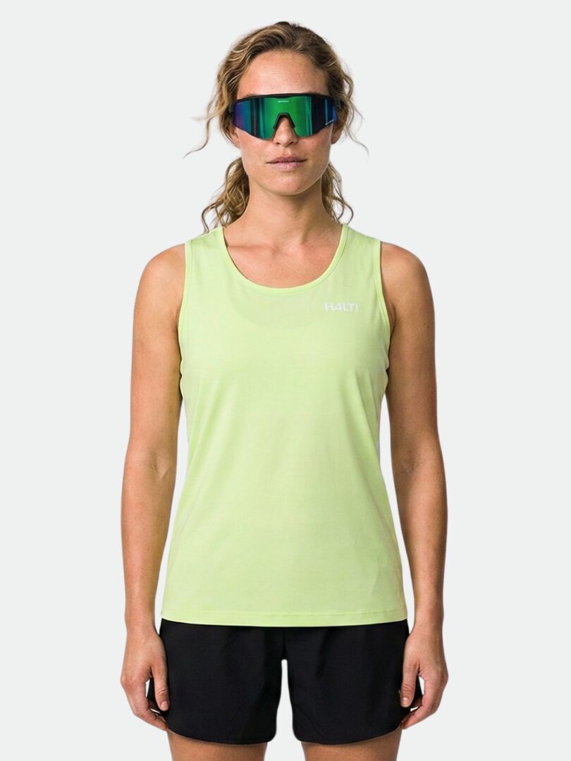 En person i ljusgrön Halti Salves Topp Dam, svarta shorts och sport-solglasögon står vänd framåt.