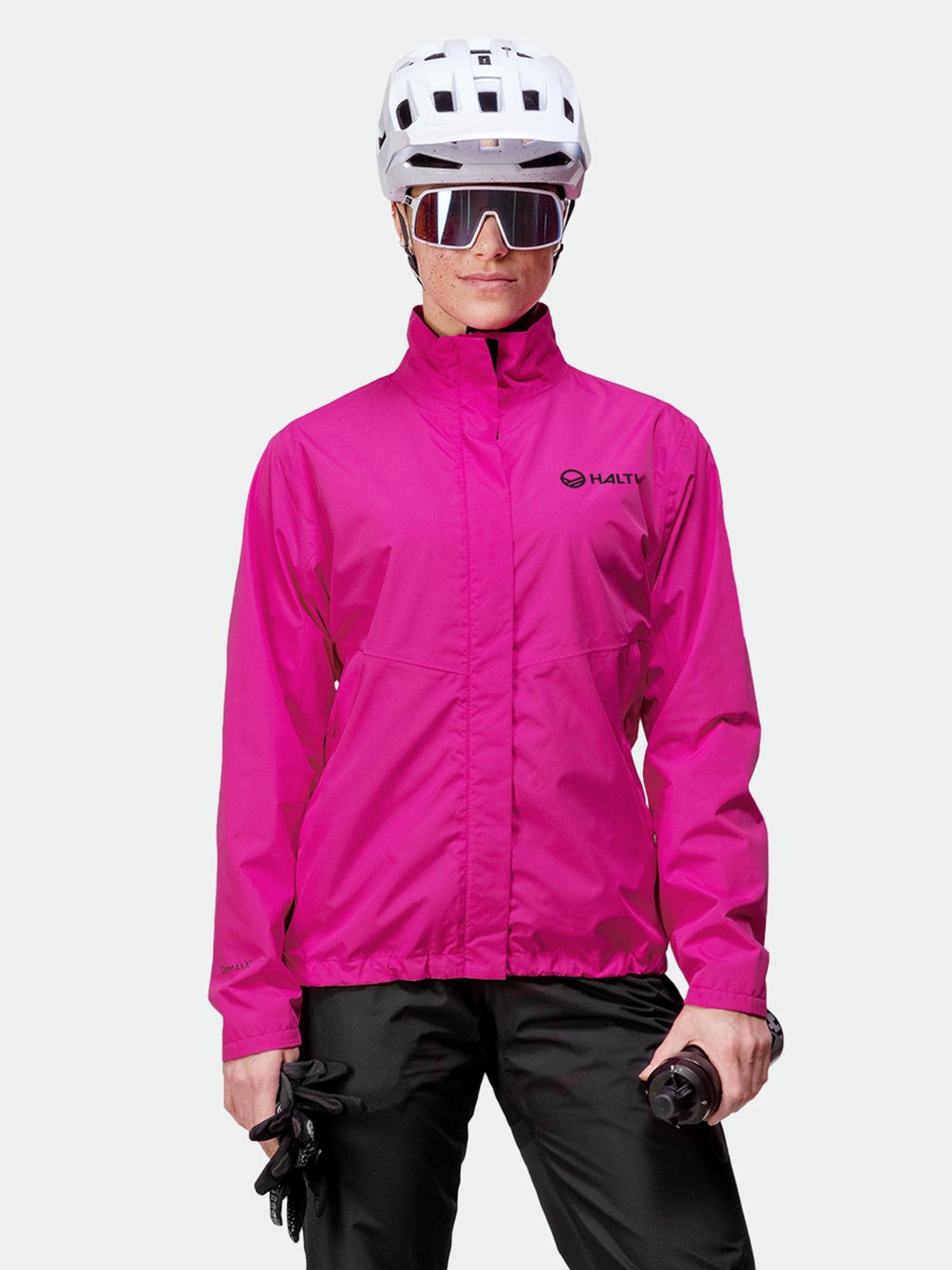 En person i en Halti Triant DX Cykeljacka Dam från Active Sport-kollektionen sitter vänd framåt och håller i handskar.