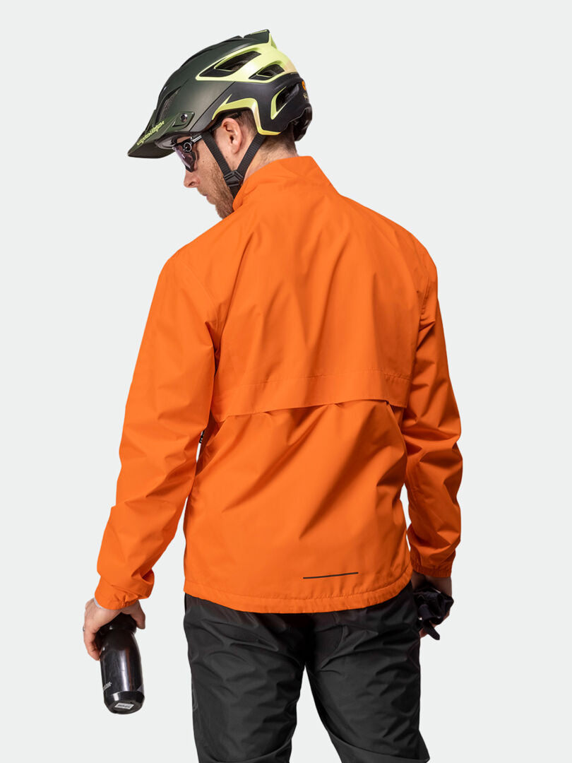 En person i en Halti Triant DX Cykeljacka Herr, svarta byxor, hjälm och solglasögon håller en vattenflaska.