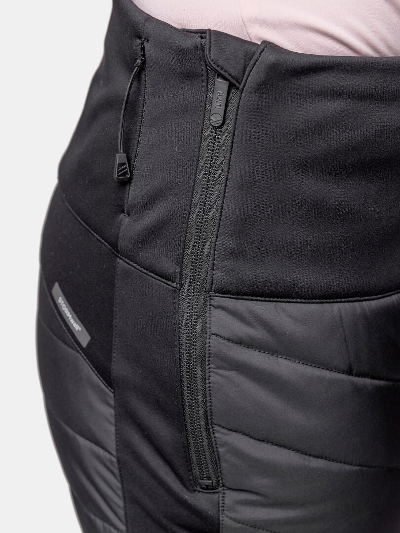 Närbild av Halti Hanki 2 Hybrid längdskidbyxor dam med dragkedja på sidan, perfekt för vinterträning, stylad med rosa topp.