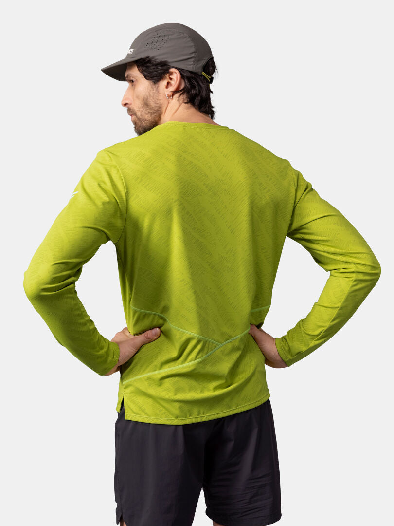 Man i Halti Oulanka Träningströja Herr (limegrön), svarta shorts, grå keps, händerna på höfterna, vänd bortåt.