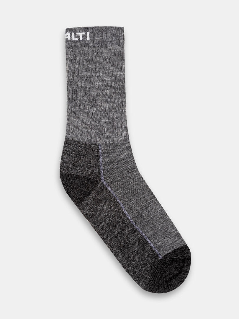 En enskild Halti Trekking Warm Merinostrumpor-strumpa i grått med mörka detaljer, avbildad mot en enfärgad vit bakgrund.