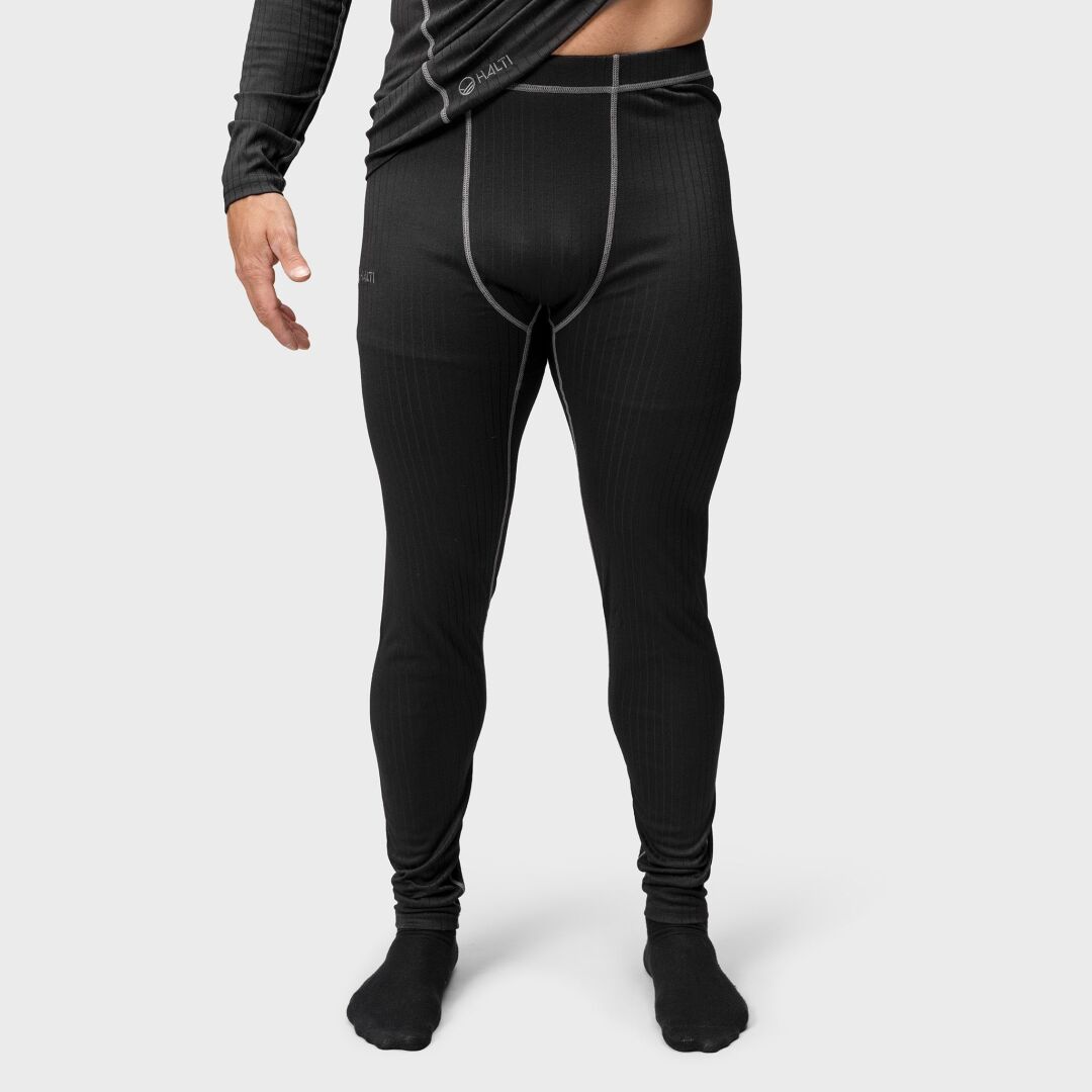 Modell bär Halti Dual Underställ Set Herr i svart, tillverkad av återvunnen polyester, mot en ljusgrå bakgrund.