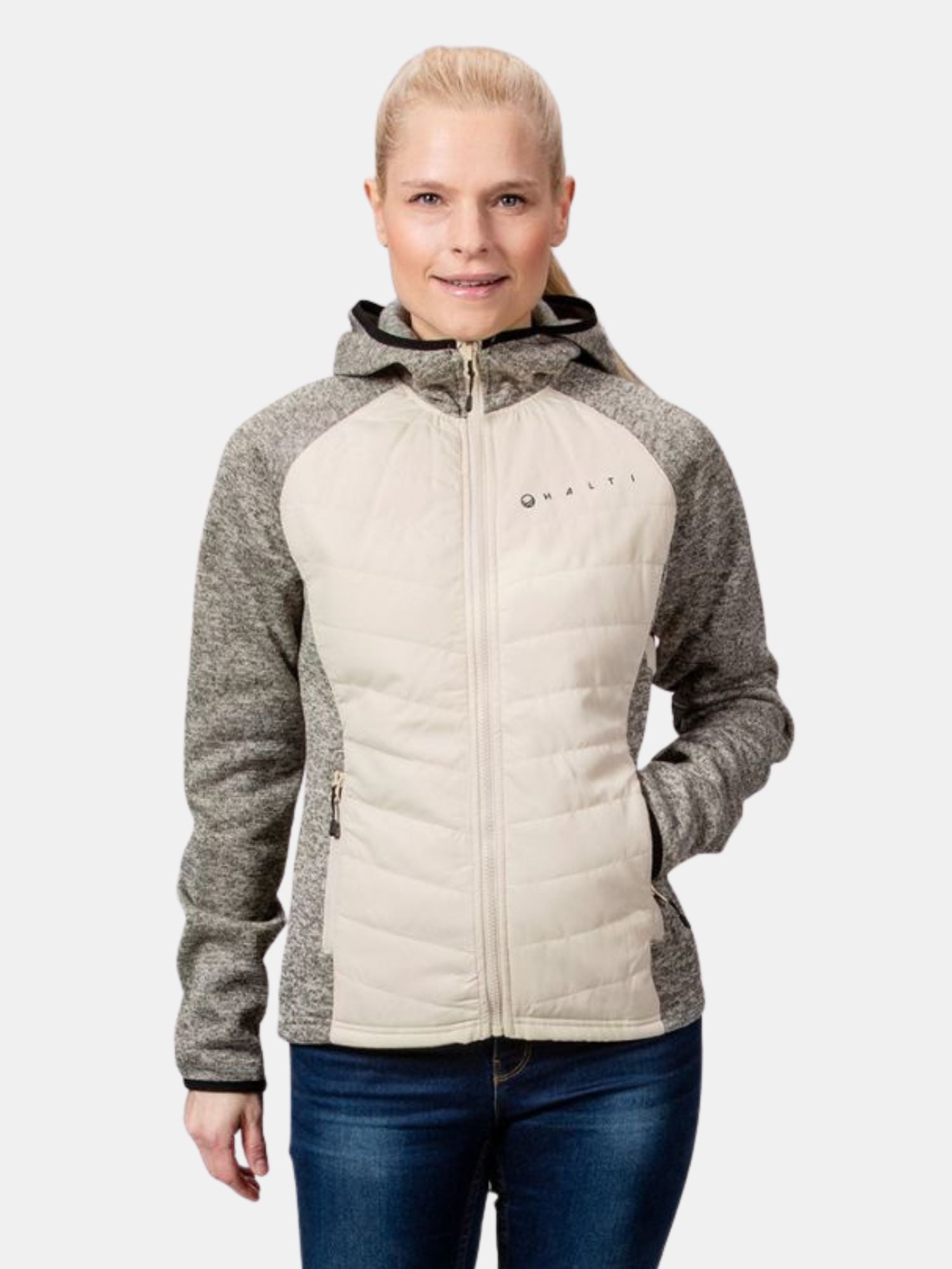 En kvinna bär Halti Streams Hybrid Mellanlager Dam, en lätt jacka med grå ärmar och huva, tillverkad av återvunnet material.