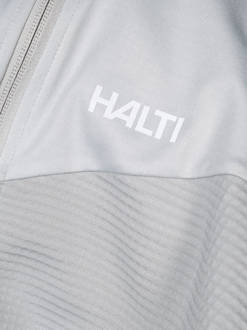 Närbild på ett Halti HeatGrid Mellanlager Herr i ljusgrått med dragkedja och logotyp, perfekt för vandring.